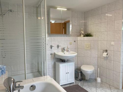 a bathroom with a sink and a shower and a toilet at Ferienwohnung Fam. Natusch in Steinhöfel