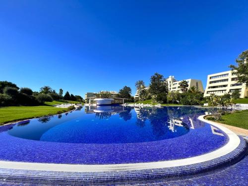 a large pool of blue water with buildings in the background at Alvor Paradise With Pool by Homing in Alvor
