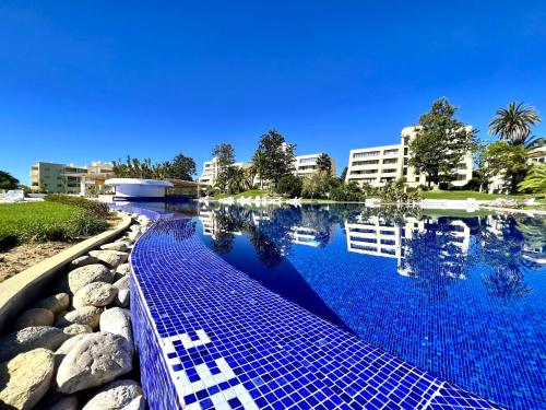 a large swimming pool with blue water in front of a building at Alvor Paradise With Pool by Homing in Alvor