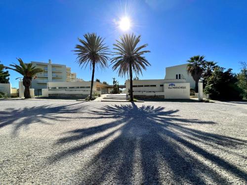 a shadow of a palm tree on a parking lot at Alvor Paradise With Pool by Homing in Alvor