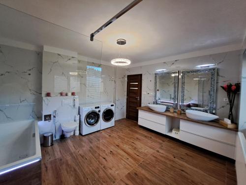 a bathroom with two sinks a washing machine and two toilets at Veselá Lama Apartmány Janovice in Ostravice