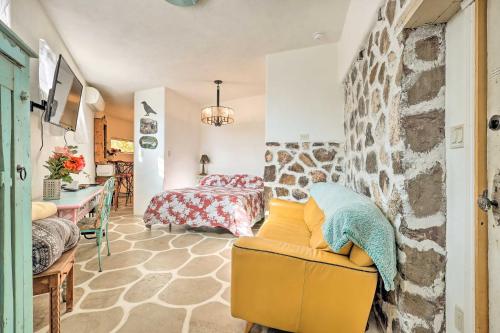 a living room with a yellow couch and a bedroom at Quirky Santa Cruz Studio with Shared Hot Tub! in Santa Cruz