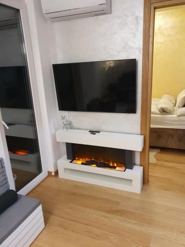 a living room with a tv and a fireplace at Centar view lux in Novi Sad