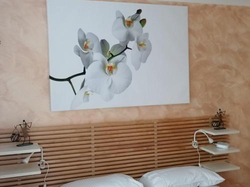 een schilderij van witte bloemen op een muur bij Beautiful and peaceful large double bedroom near Olympic Park in Stratford London in Londen