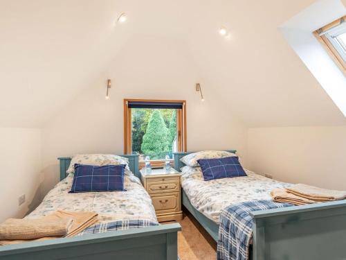 two beds in a room with a window at Brindleshaw Barn in Meopham