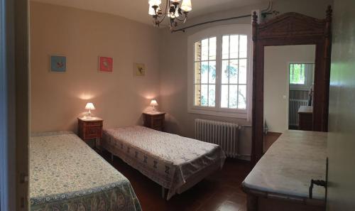 Cette chambre comprend 2 lits et un miroir. dans l'établissement le murmure des oliviers, à Castillon-du-Gard