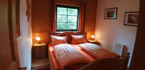 a bedroom with a bed with two lamps on it at Berghaus Julia in Sankt Englmar