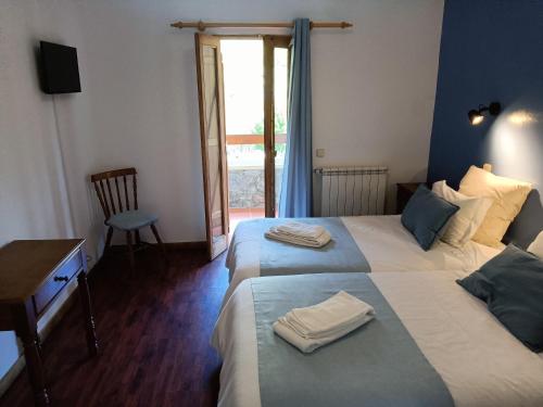 a hotel room with two beds with towels on them at Quinta de Leandres in Manteigas