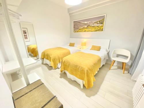 una habitación de hotel con 2 camas y una silla en CARRERA HOME, en Granada