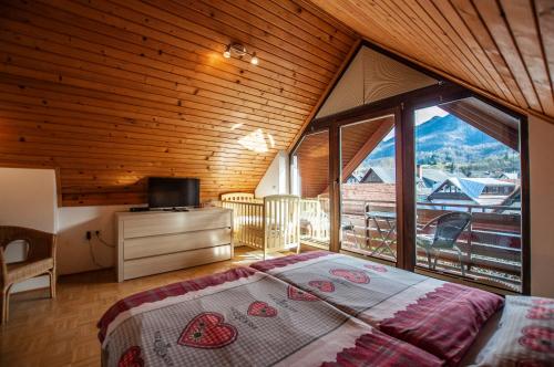a bedroom with a bed and a large window at Guest House Alenka in Bohinj