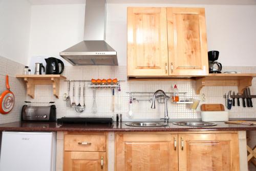a kitchen with wooden cabinets and a sink at Apartments Vila ViDa Orebić in Orebić