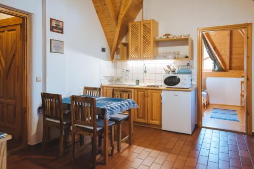 eine Küche mit einem Tisch und Stühlen im Zimmer in der Unterkunft Kormorán Vendégház in Tiszafüred