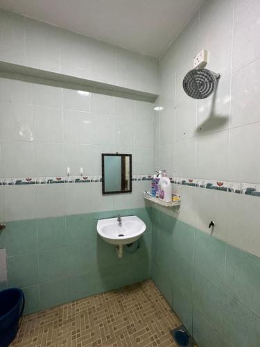 a bathroom with a sink and a mirror at D'beeba Homestay in Pedas