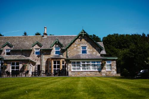 a large stone house with a large grass yard at Westlands of Pitlochry in Pitlochry