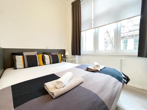 een slaapkamer met een groot bed en handdoeken bij Agape Apartments in Zagreb