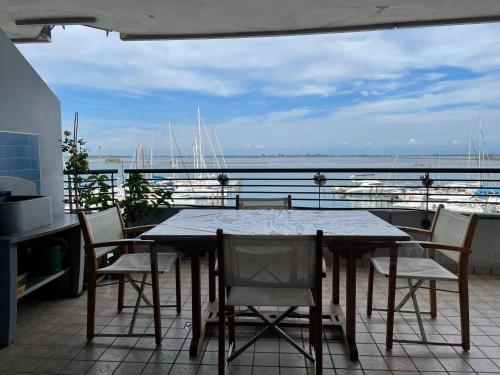 a table and chairs on a balcony with a view of the water at Costa Azzurra Aparment in Grado