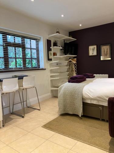 a bedroom with a bed and a table and chairs at The Burrow in Wellesbourne Hastings
