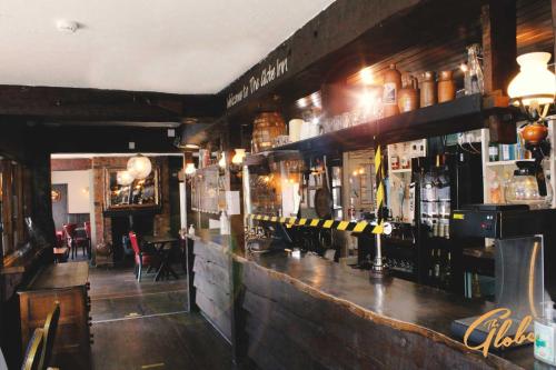 - un bar avec de nombreuses bouteilles d'alcool dans l'établissement The Globe Inn, à Tiverton