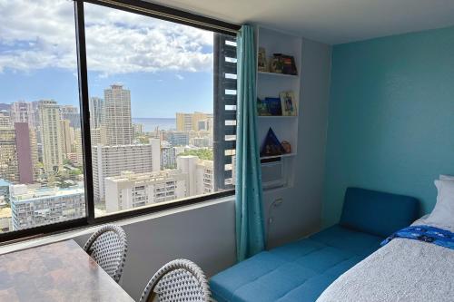 a bedroom with a blue bed and a large window at Waikiki Condo High Floor Views Beaches Convention Center in Honolulu