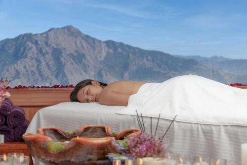 una mujer acostada encima de una cama en Koti Resort, en Shimla
