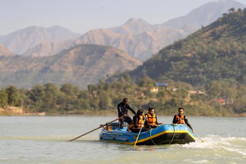eine Gruppe von Menschen in einem Boot auf einem Fluss in der Unterkunft Koti Resort in Shimla