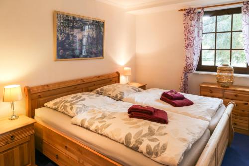 een slaapkamer met een bed met twee rode kussens erop bij VILLA LILIA - das charmante Ferienhaus am See in Potsdam in Potsdam