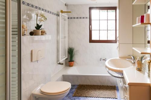 ein Badezimmer mit einer Badewanne, einem WC und einem Waschbecken in der Unterkunft VILLA LILIA - das charmante Ferienhaus am See in Potsdam in Potsdam