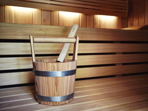 a wooden bucket in a sauna with two knives in it at Hotel Emocja SPA in Mielno
