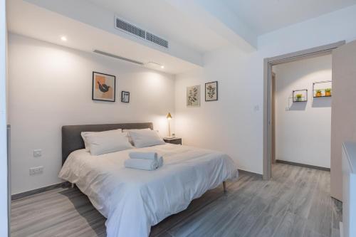 1 dormitorio con 1 cama con colcha blanca en Luxury property in Gzira just minutes away from the seafront and Restaurants, en Il-Gżira