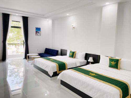 um quarto branco com 2 camas e um sofá em Le Phan Hotel em Tây Ninh