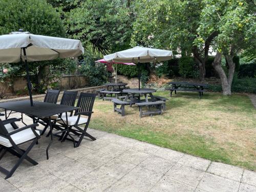 a group of tables and benches with umbrellas at Mansfield Lodge Hotel Ltd in Mansfield
