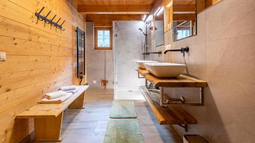 a bathroom with two sinks and a shower with a tub at Ferienhaus Untergladner in Schladming