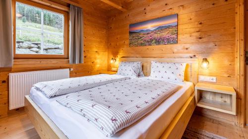 sypialnia z łóżkiem w drewnianym domku w obiekcie Ferienhaus Untergladner w Schladming