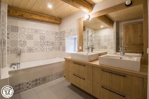 y baño con 2 lavabos, bañera y tubermottermott. en LA VIE D'ANCE, en Saint-Anthème