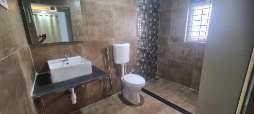 a bathroom with a toilet and a sink and a mirror at RK island view 3 bedroom apartment in Dabolim