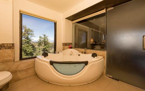 un ampio bagno con vasca e WC di Koti Resort a Shimla