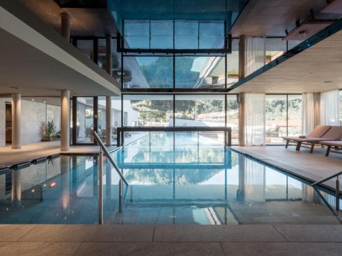 a house with a pool with glass walls at Biohotel Rupertus in Leogang