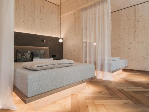 sypialnia z 2 łóżkami w pokoju z drewnianą podłogą w obiekcie Biohotel Rupertus w mieście Leogang