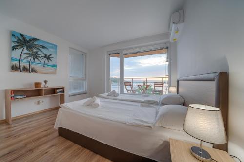 a bedroom with a large bed with a view of the ocean at Moana Lighthouse Apartment in Ahtopol