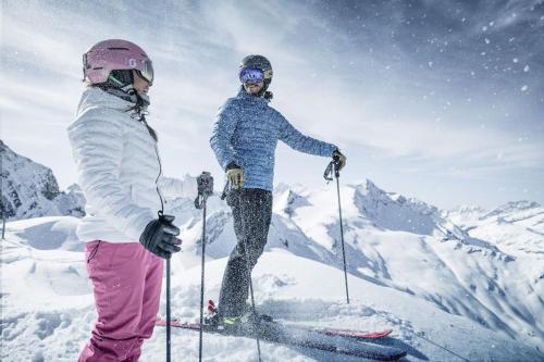 two people on skis in the snow on a mountain at Chalet Gletschermoos - Summer Card included in Zell am See