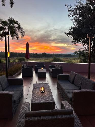 a patio with couches and a table and a sunset at I love phants Lodge in Ban Huai Thawai