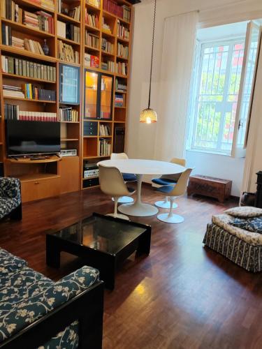 a living room with a table and chairs and bookshelves at residenza San Martino in Naples