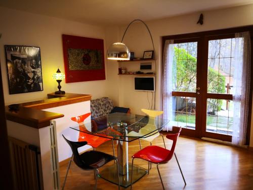 sala de estar con mesa de cristal y sillas rojas en Chalet Luna, en Caspoggio