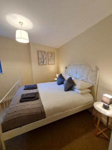 a bedroom with a large white bed with blue pillows at Cardiff City centre Apartment lifestyle!! in Cardiff