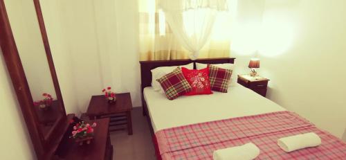 a bedroom with a bed with red pillows at Southern Comforts - Galle Fort in Galle