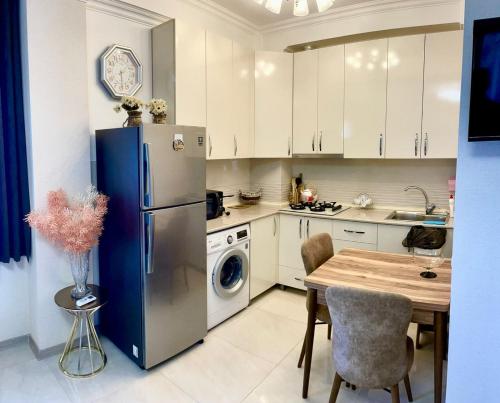 a kitchen with a refrigerator and a table with chairs at Central City in Kutaisi