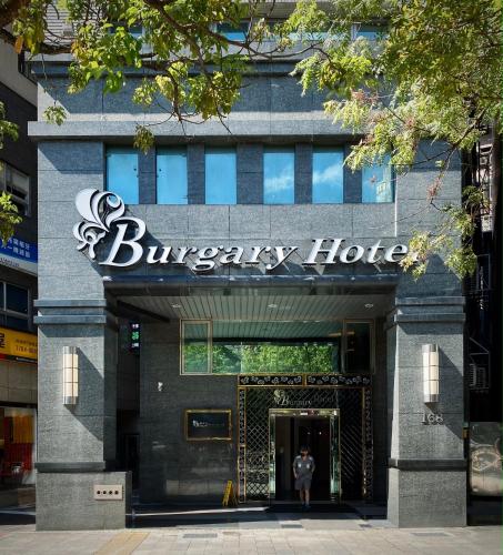 台北市にあるバーガリー ホテルの建物の前に立っている男性