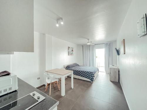 a kitchen with a table and a bed in a room at Studios CC Victoria Ocean View in Playa de las Americas