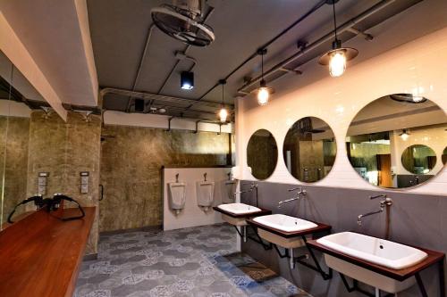 a bathroom with three sinks and three mirrors at Lana Beds & Space in Chiang Mai