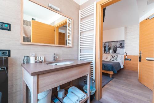 a bathroom with a sink and a bed in a room at Albergo Caffe Centrale in Mezzocorona